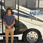 Max standing by MOM Bus with logo